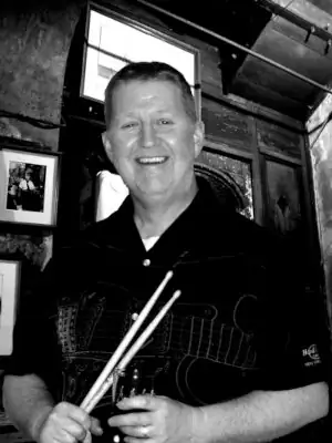 Bill Butterworth drummer Bill posing with drumsticks in a New Orleans bar